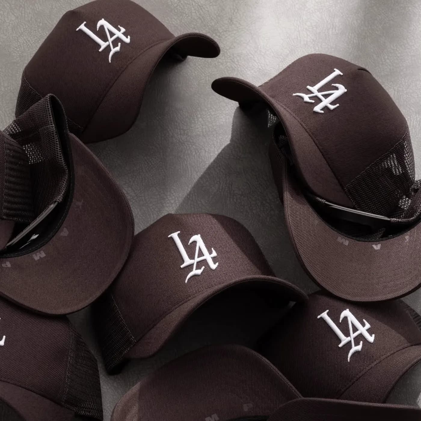 Stack of dark caps with raised white embroidered logos