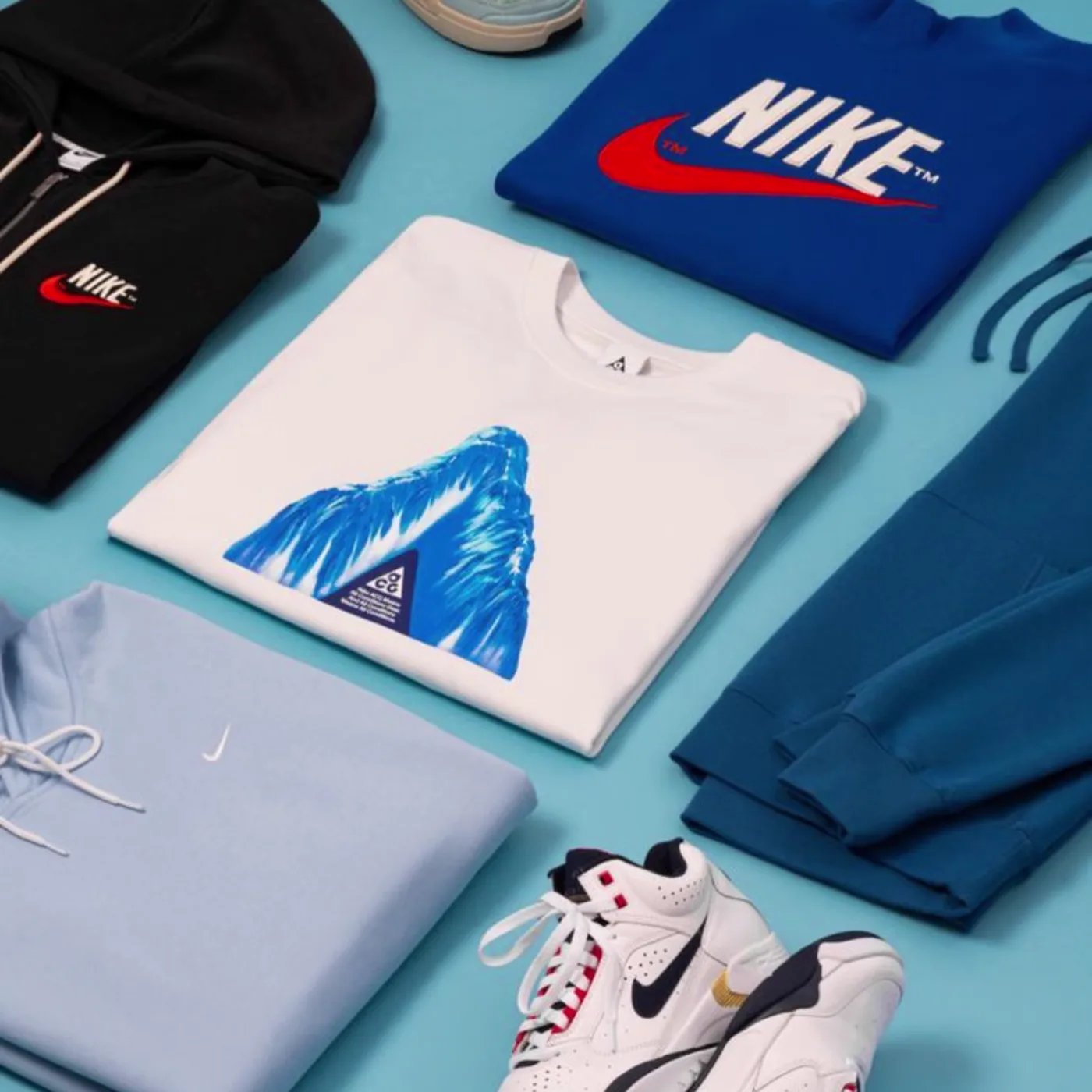Flat-lay of printed graphic garments on a blue studio surface