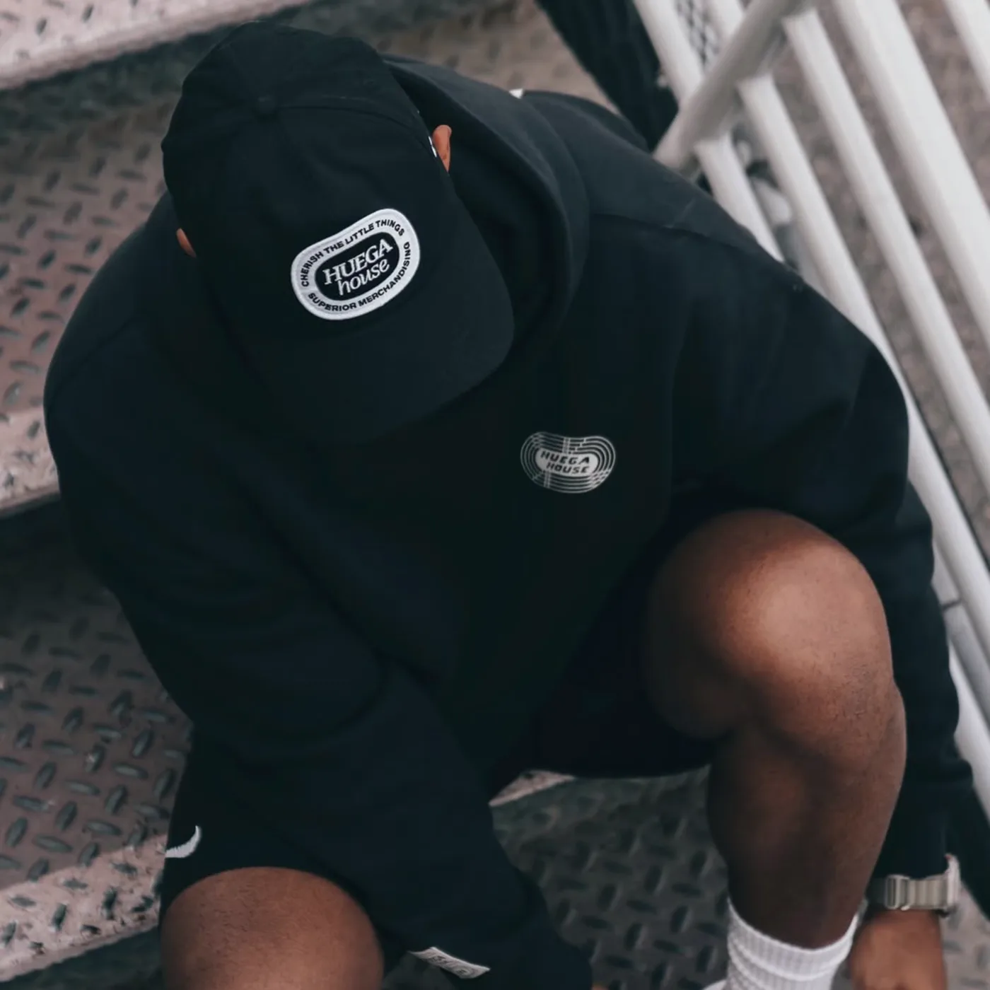 Close view of embroidered branding on a black cap and garment